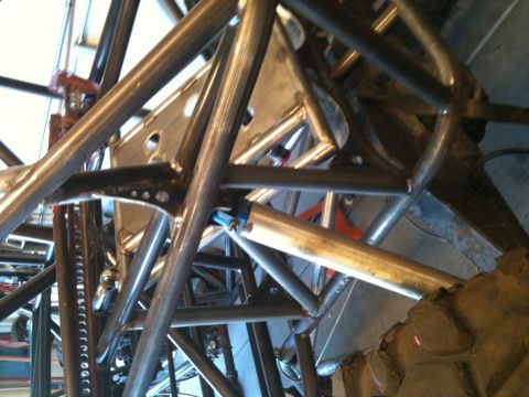 1966 Ford Bronco - Close-up view of a custom buggy's intricate roll cage structure, a shock absorber and chain drive components.