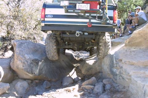 1994 Ford Bronco - Ford Bronco tackling a difficult rocky trail, showing its rear axle and tires.