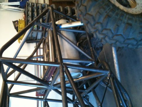 1966 Ford Bronco - Close-up of a custom off-road buggy's tubular roll cage and suspension components.