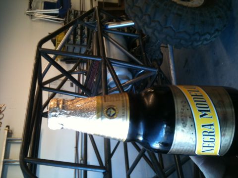 1966 Ford Bronco - A Negra Modelo beer bottle rests against the roll cage and tire of an off-road buggy.