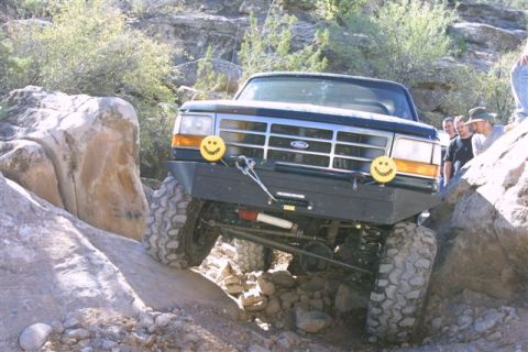 1994 Ford Bronco - This modified Ford Bronco navigates a rocky off-road obstacle with a group of onlookers.