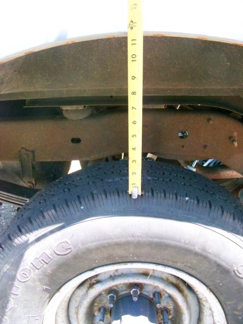 1989 Ford Bronco - Measuring the distance between the tire and the wheel well to assess suspension height.