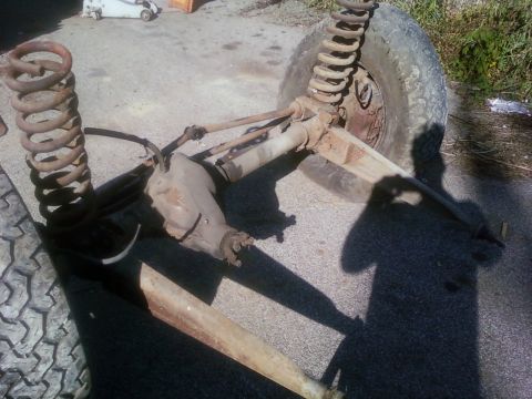 1989 Ford Bronco - Front axle assembly with coil springs and tire, likely for an off-road vehicle.
