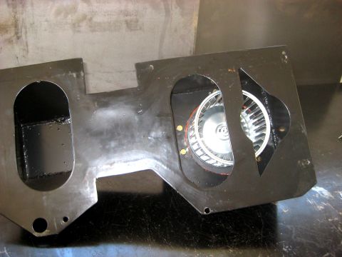 1996 Ford Bronco - A black metal housing for a blower motor, containing two fans, is shown from an angled perspective.