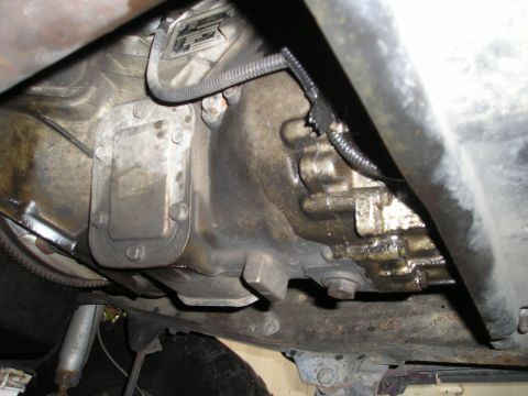 1997 Ford F-250 - Underside view of a vehicle's transmission and transfer case, showing various components and some grime.