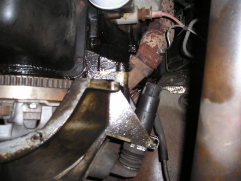 1997 Ford F-250 - Engine oil is leaking from the engine block and exhaust manifold shows rust.