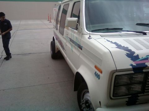 2000 Mercury Grand Marquis - A white van with colorful graphics and a '460' badge is parked on a concrete surface.