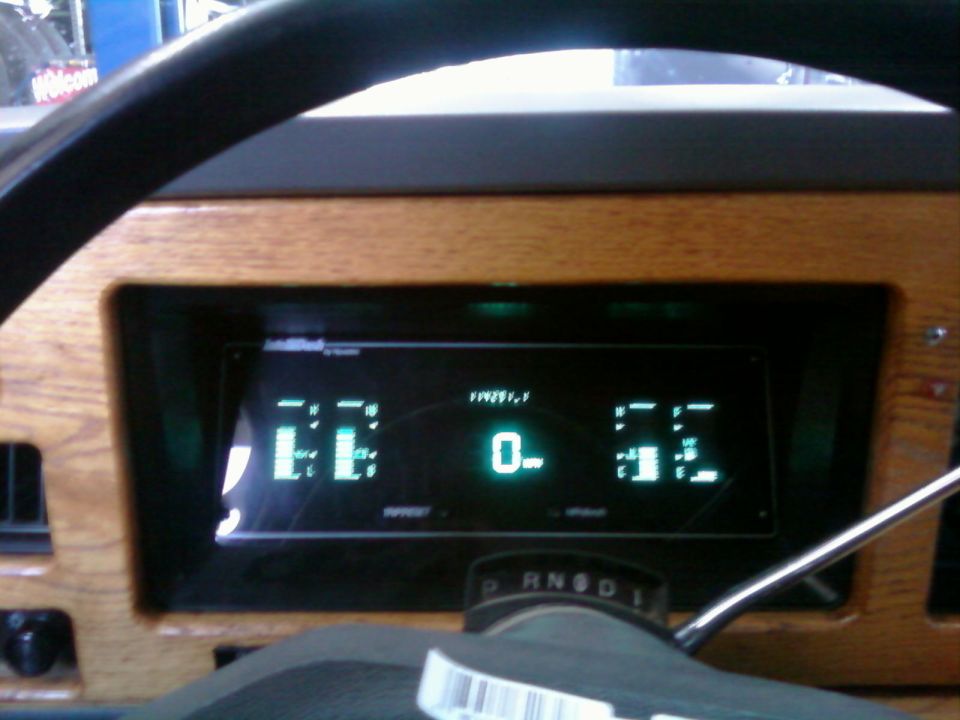Digital dashboard with wood grain trim, showing 0 miles and 'EE' and '52' indicators