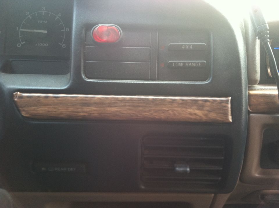 Dashboard with woodgrain trim, tachometer, 4x4 and low range buttons, and air vents
