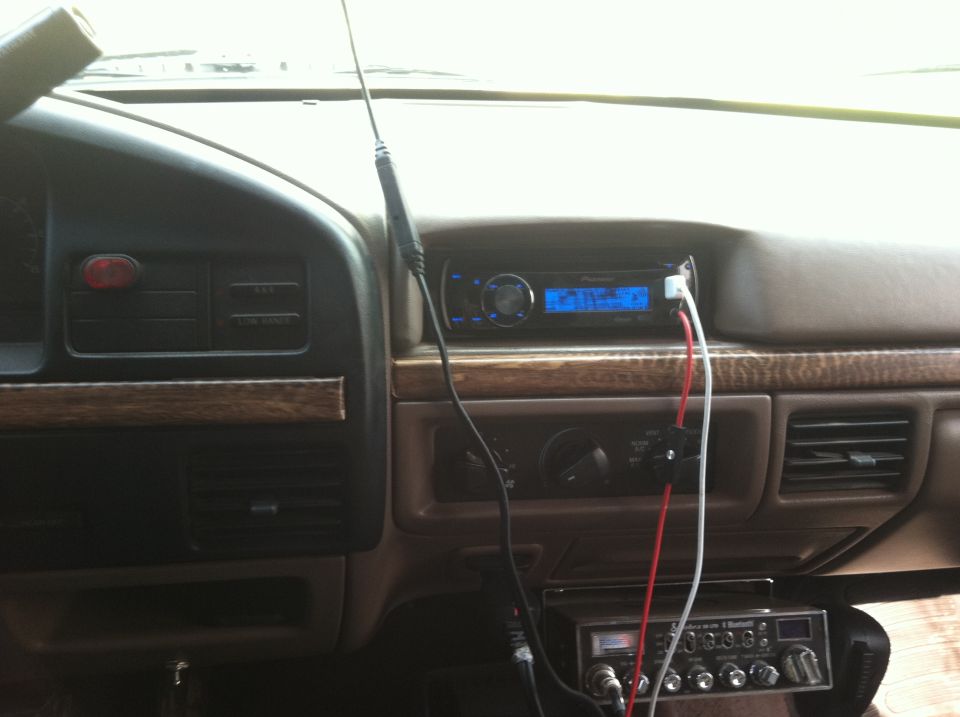 Dashboard with aftermarket radio and CB radio installed. Woodgrain trim visible