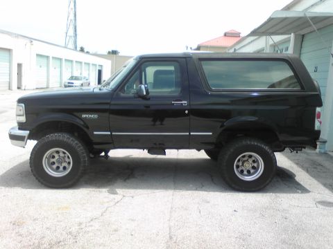 1995 Ford Bronco - Side profile of a black 1995 Ford Bronco parked outdoors.