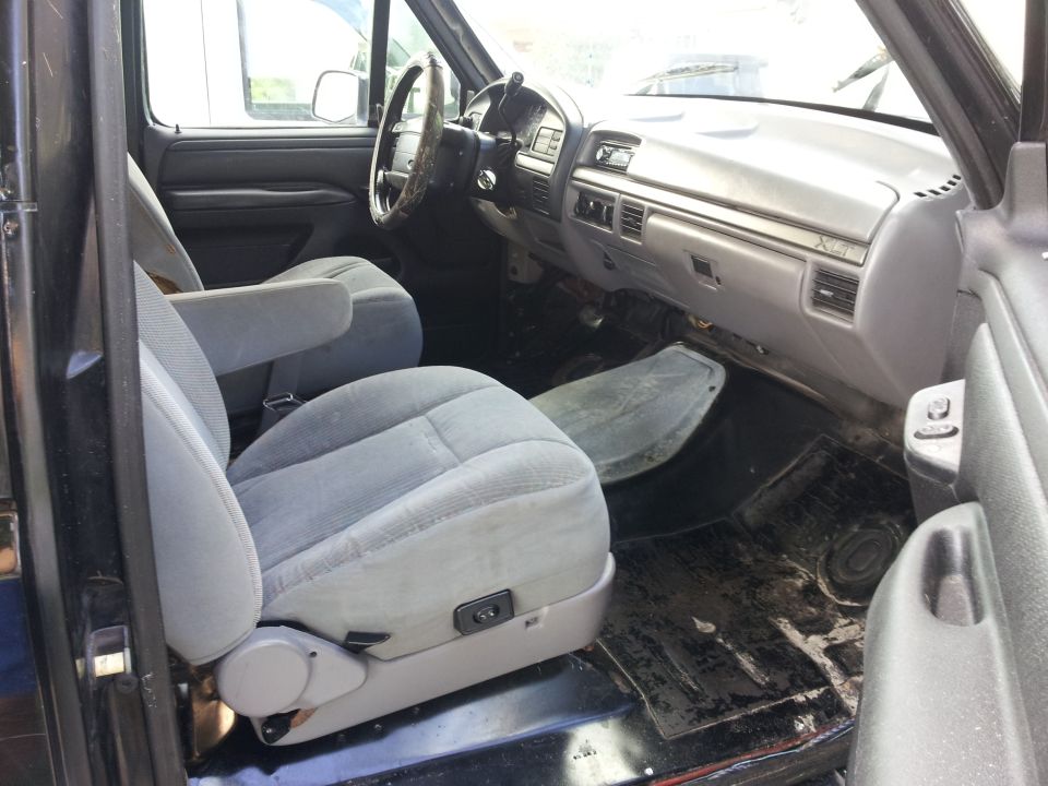 Gray cloth bucket seats and dashboard of a truck interior. A Supermotors.net watermark is visible