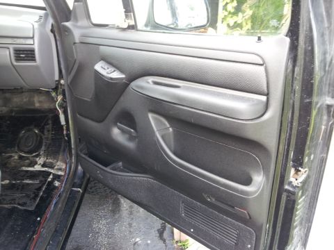 1995 Ford Bronco - Interior view of a black door panel with visible wiring and floor details.