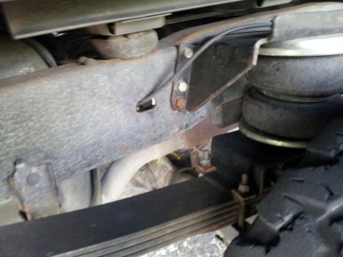 1995 Ford Bronco - Underside view of a vehicle's suspension system, showing leaf springs and an air helper bag.