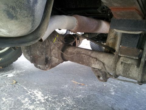 1995 Ford Bronco - Undercarriage view of a vehicle's rear axle and suspension system.