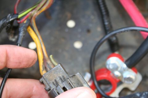 1982 Ford Bronco - Close-up of an automotive wiring harness connector and battery terminal connections.