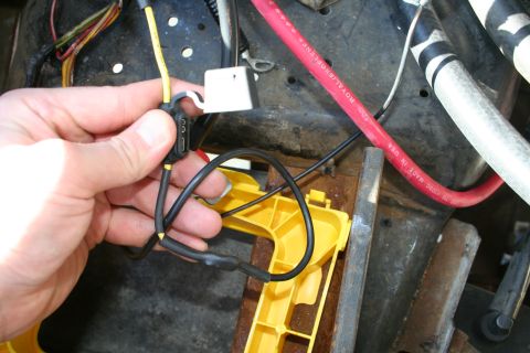 1982 Ford Bronco - Close-up of electrical wiring and a fuse holder being manipulated by a hand.