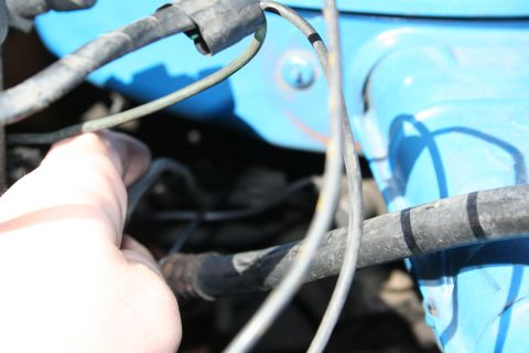 1982 Ford Bronco - A hand is shown near engine wiring and a blue component, with the Supermotors logo visible.
