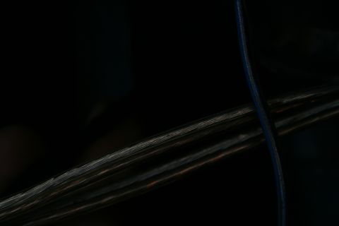 1982 Ford Bronco - A close-up view of a vehicle's wiring harness, showing a bundle of wires and a single blue wire.