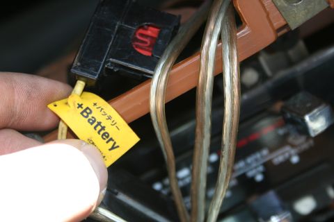 1982 Ford Bronco - Close-up of a yellow tag indicating a positive battery connection on a wiring harness.