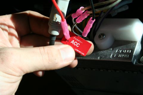 1982 Ford Bronco - A hand holds a red tag labeled ACC, indicating accessory wiring, near electrical connections.