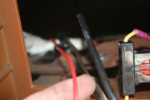 1982 Ford Bronco - Close-up of a vehicle's wiring harness, showing red and yellow wires connected to a black connector.