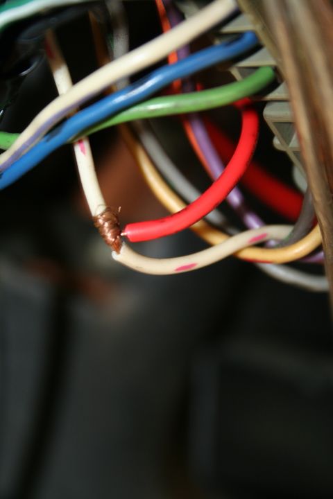 1982 Ford Bronco - Damaged wiring harness with exposed copper wire and several colored electrical cables visible.