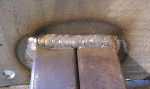 1990 Ford Bronco - Close-up view of welded metal sliders, showing the weld seams and a portion of the metal surface.