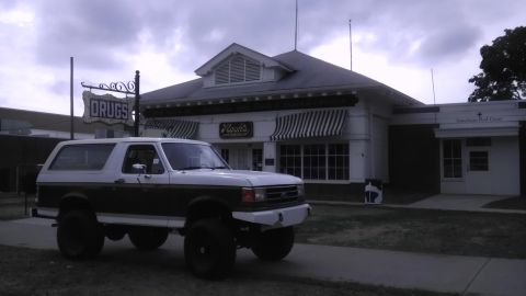 1989 Ford Bronco - This lifted Ford Bronco is parked in front of a historic building that appears to be a former drug store and American Red Cross location.
