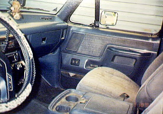 Passenger-side interior of an older Ford truck showing dash, door and bench seat
