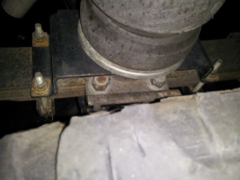1995 Ford Bronco - A close-up view of a vehicle's suspension system, showing a leaf spring and air bellows.