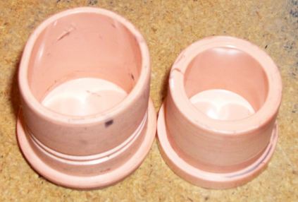 1996 Ford Bronco - Two pink plastic caps are shown on a textured surface.