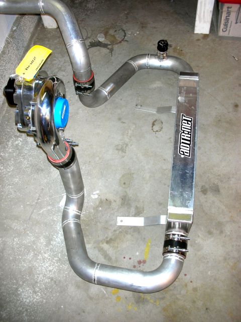 2004 Ford Crown Victoria - Aftermarket turbocharger and intercooler system components laid out on a concrete surface.