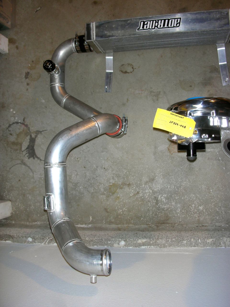 Intercooler piping with a blow-off valve and an air filter assembly. ADTR.net logo visible on intercooler