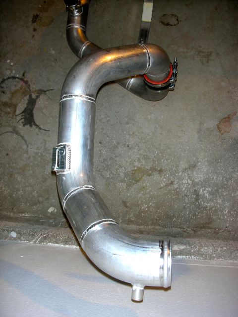 2004 Ford Crown Victoria - A custom exhaust pipe assembly is shown hanging against a concrete wall.