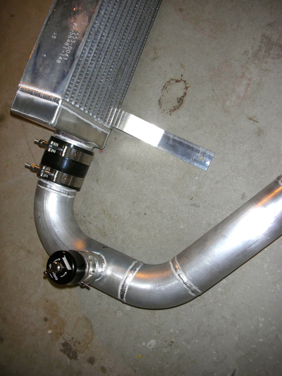 Aluminum intercooler with black hose clamps and a blow-off valve