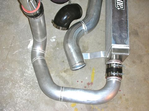 2004 Ford Crown Victoria - Close-up of custom aluminum intercooler piping and an air filter, likely for a performance vehicle modification.