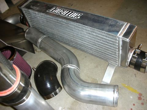 2004 Ford Crown Victoria - A collection of intercooler and piping components, including a prominent intercooler with a visible brand logo.