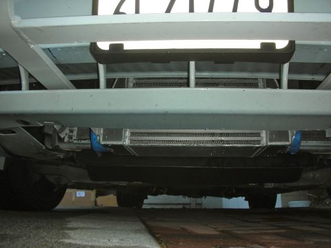 2004 Ford Crown Victoria - A low-angle shot reveals the underside of a vehicle, highlighting an installed supercharger system and a portion of its license plate.