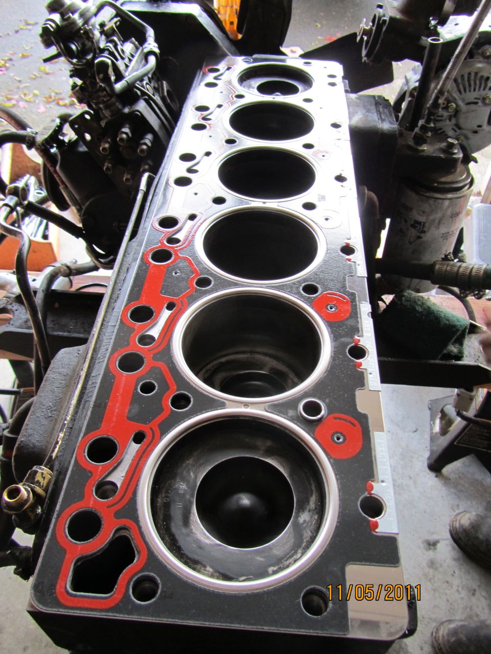 Engine cylinder head gasket with red sealant around the bores