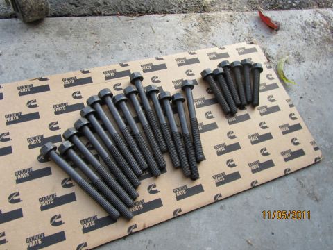 1984 Ford Bronco - Engine bolts are laid out on cardboard packaging for Cummins Genuine Parts.