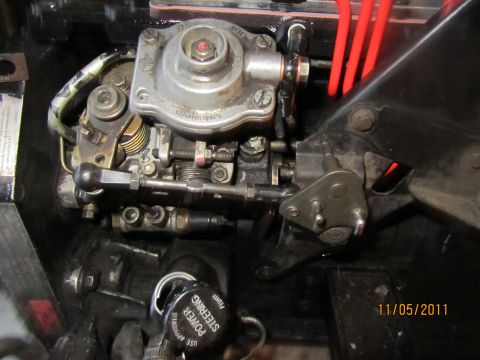 1984 Ford Bronco - Close-up view of a diesel injection pump assembly, showing various mechanical linkages and red hoses.