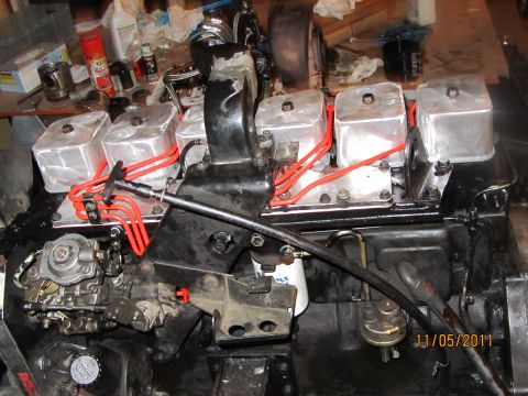 1984 Ford Bronco - Close-up view of an engine, likely a diesel, with aluminum valve covers and red fuel lines visible.