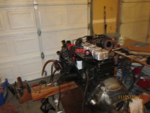 1984 Ford Bronco - Engine assembly with turbocharger is shown on a stand in a garage setting.