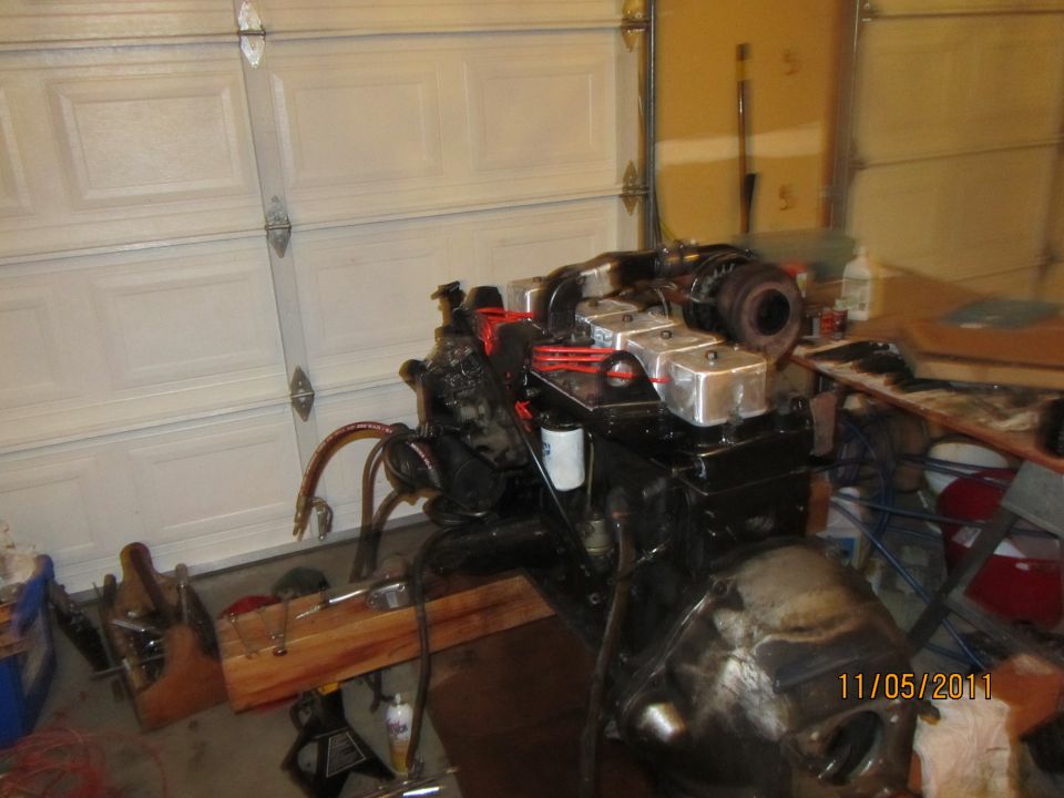 Engine assembly with turbocharger, mounted on a stand in a garage