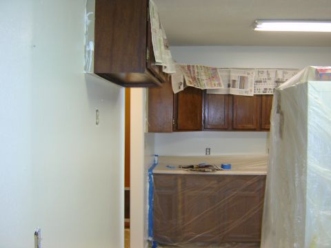 1984 Ford Mustang - A kitchen is undergoing renovation, with cabinets and appliances covered for protection.