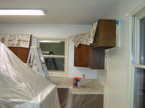 1984 Ford Mustang - A kitchen is being renovated, with cabinets covered in protective plastic and a ladder set up.