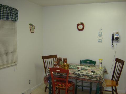 1984 Ford Mustang - A dining area scene features a table set for a meal, with decorative items on the wall and a landline phone.