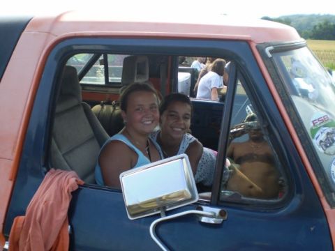 1978 Ford Bronco - Two girls smile from inside a 1978 Ford Bronco, with a reflection of a man visible in the side window.