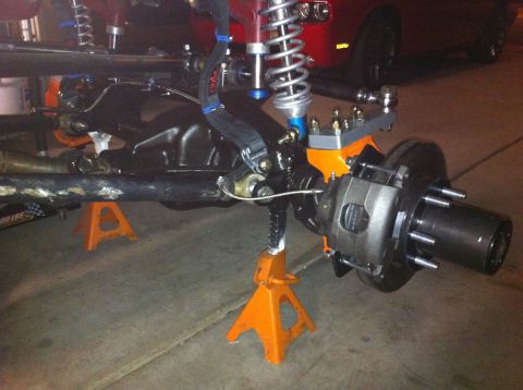 Suzuki Samurai - Close-up of a vehicle's front axle assembly supported by orange jack stands.